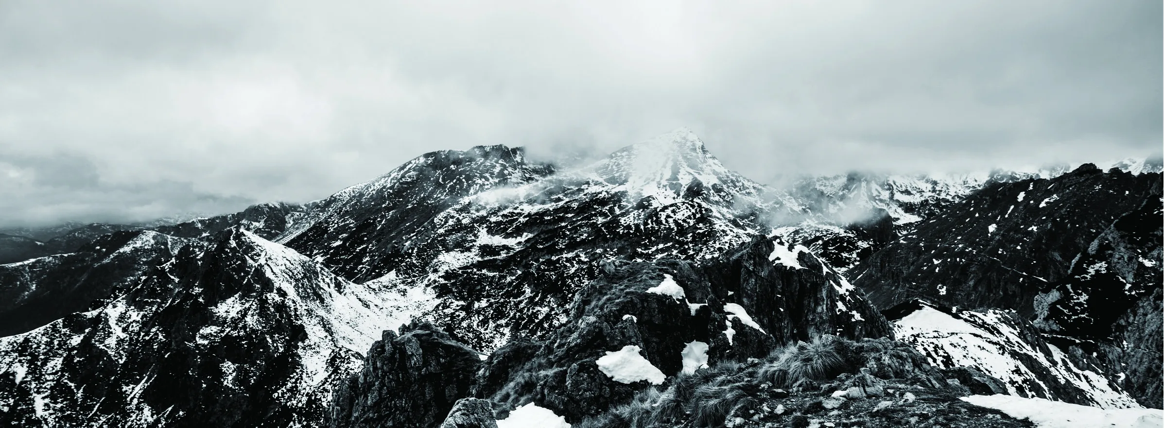 A black-and-white alpine mountain panorama